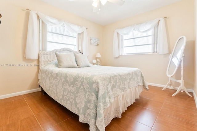 bedroom with tile patterned flooring, ceiling fan, and baseboards