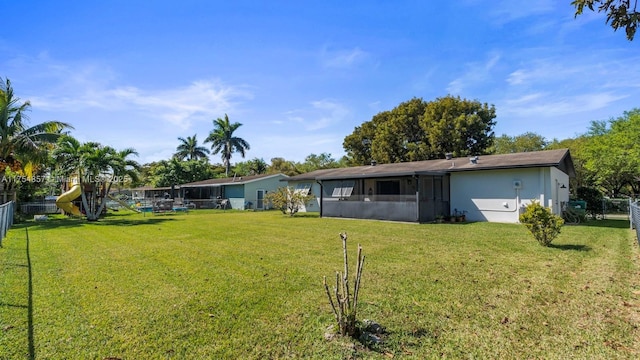 back of house with a lawn, fence, and a sunroom