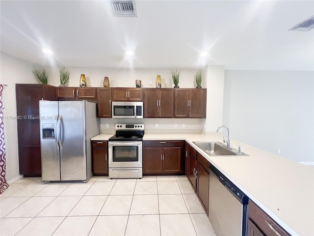 kitchen with visible vents, stainless steel appliances, a sink, and light countertops