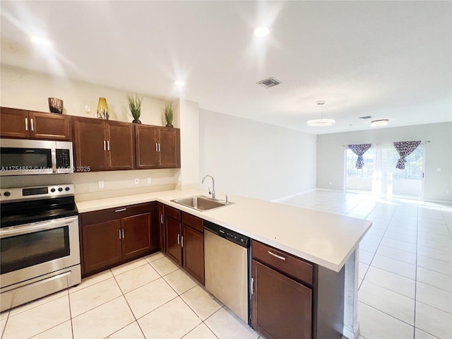 kitchen with a peninsula, a sink, visible vents, light countertops, and appliances with stainless steel finishes