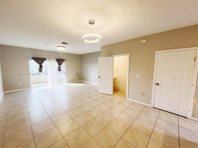 unfurnished room featuring light tile patterned floors and baseboards