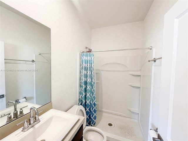 bathroom featuring a shower with curtain, vanity, and toilet