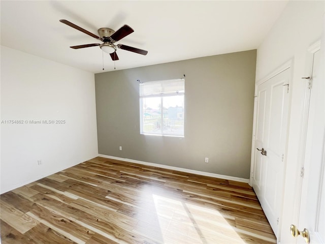 unfurnished bedroom featuring a ceiling fan, baseboards, and wood finished floors