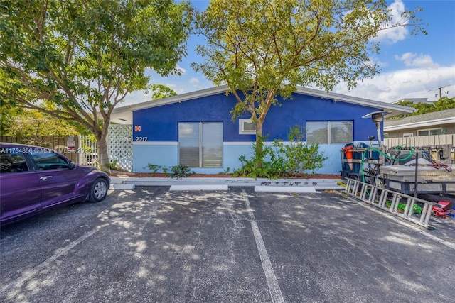 view of property featuring uncovered parking and fence