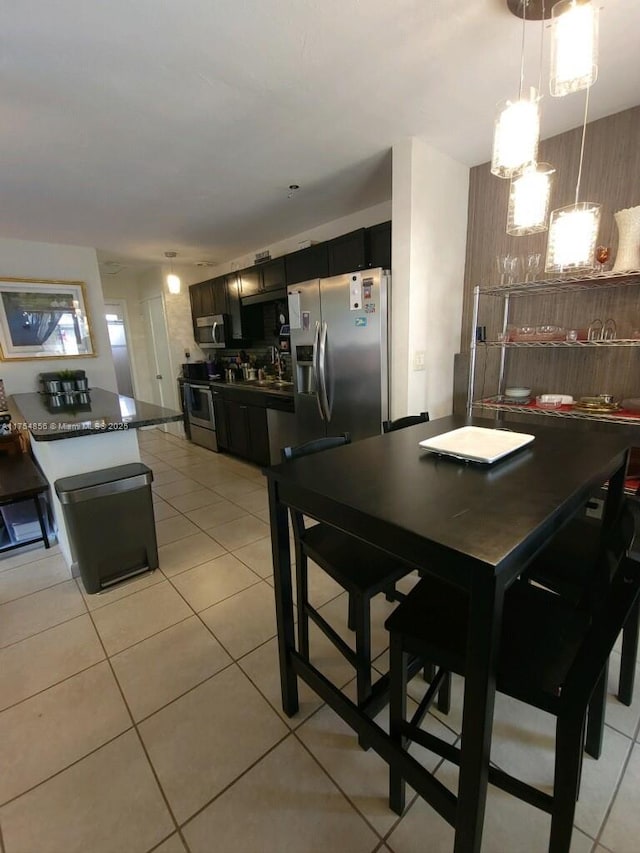 2217 NE 14th Ave, Wilton Manors, FL 33305 - kitchen featuring dark countertops, stainless steel appliances, a sink, and light tile patterned flooring