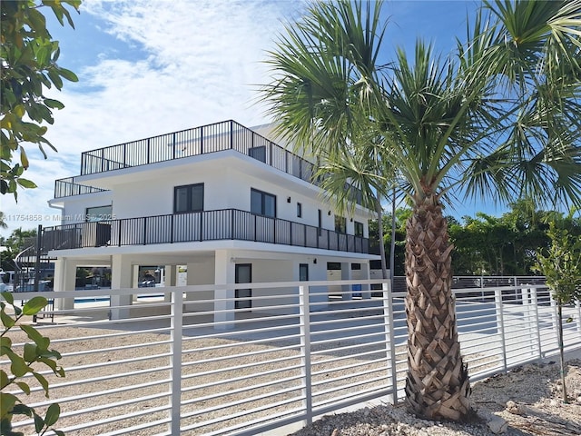 view of building exterior featuring a swimming pool and fence