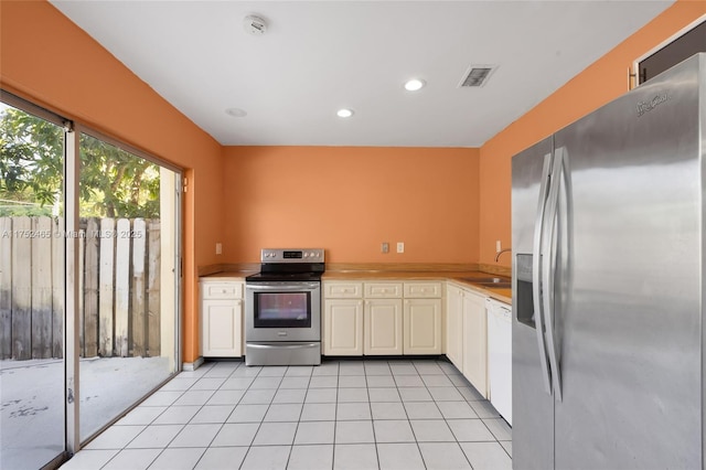 kitchen featuring light tile patterned floors, a sink, visible vents, light countertops, and appliances with stainless steel finishes