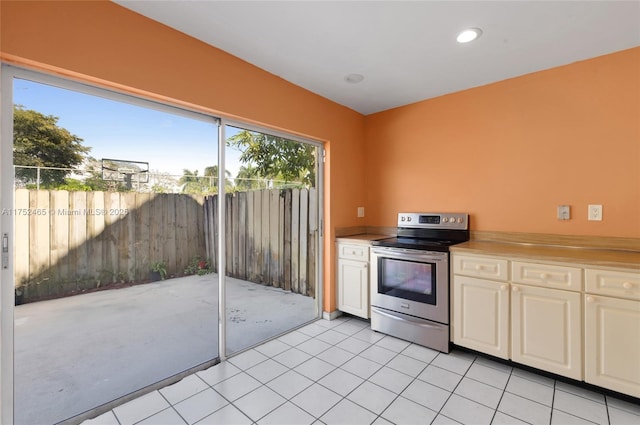 kitchen featuring light countertops, white cabinets, stainless steel electric range, and light tile patterned flooring