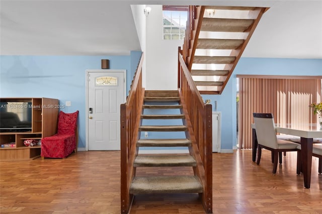 stairway with baseboards and wood finished floors