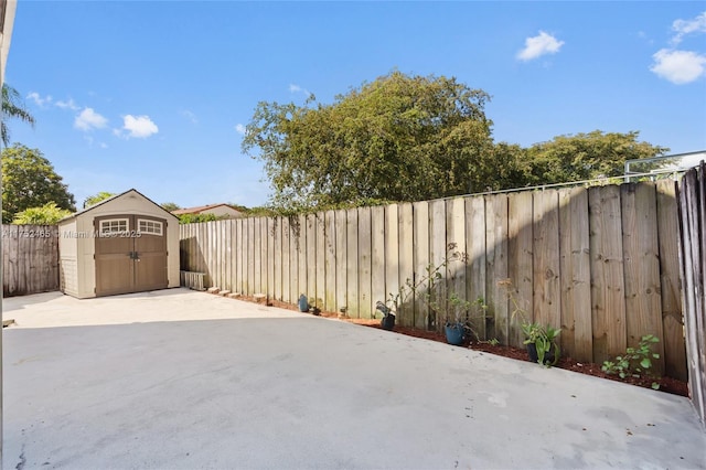 view of patio featuring a shed, an outdoor structure, and a fenced backyard