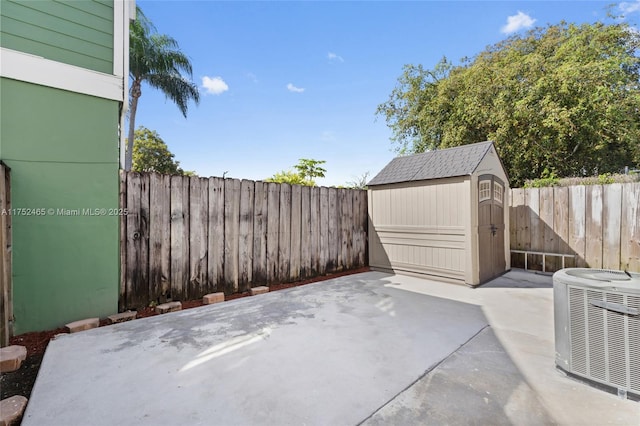 view of patio / terrace with central AC, an outdoor structure, a fenced backyard, and a shed