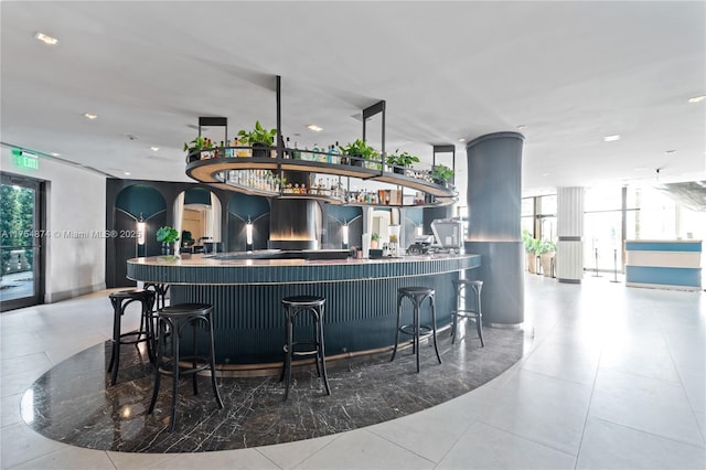 bar featuring a bar, tile patterned flooring, and floor to ceiling windows