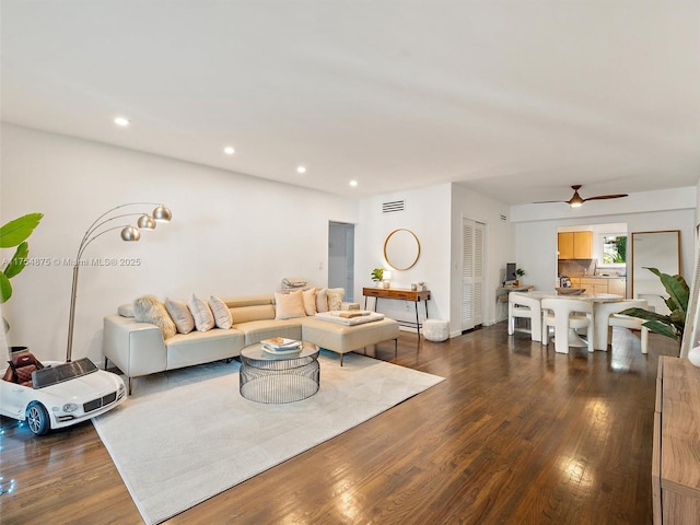 living room with dark wood-type flooring, recessed lighting, visible vents, and a ceiling fan