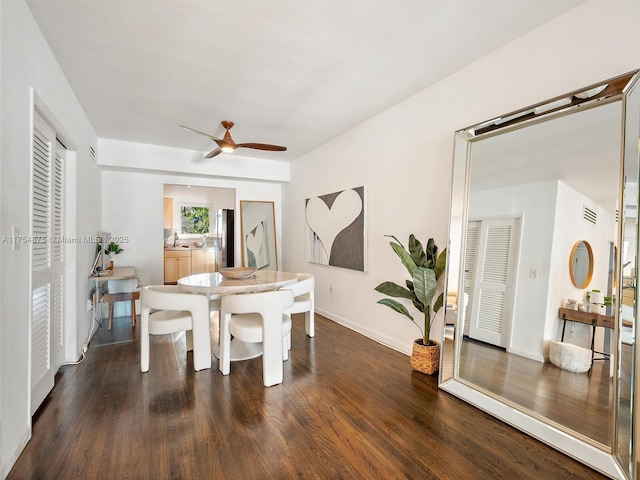 dining room featuring baseboards, dark wood finished floors, and a ceiling fan