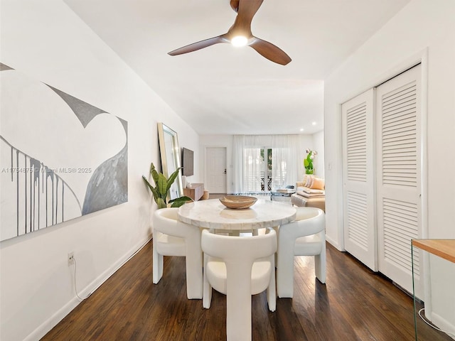 dining space featuring a ceiling fan, baseboards, and dark wood-type flooring