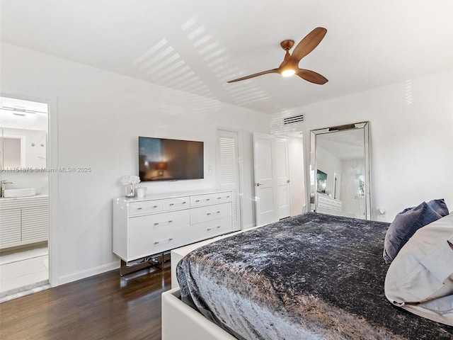 bedroom featuring visible vents, ensuite bathroom, dark wood-type flooring, ceiling fan, and baseboards