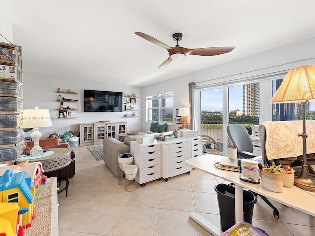 living area with light tile patterned floors and ceiling fan