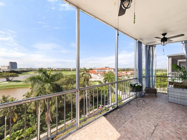 balcony with a water view and a ceiling fan