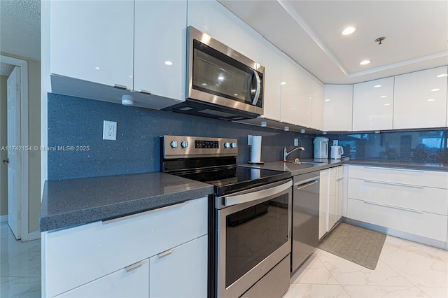kitchen with white cabinets, a sink, appliances with stainless steel finishes, modern cabinets, and marble finish floor