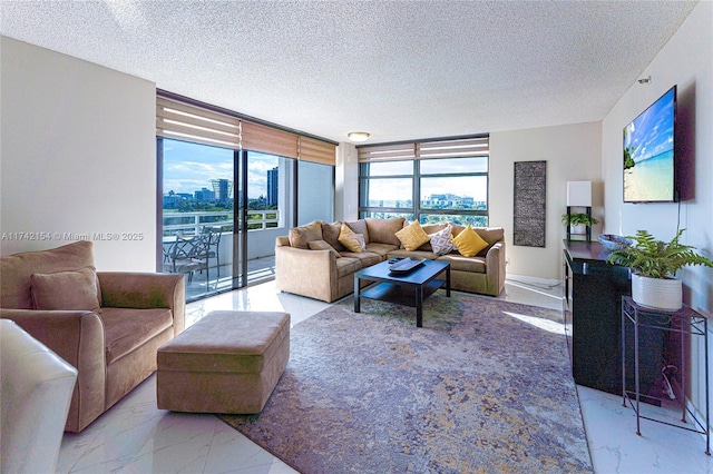 living area with a textured ceiling, marble finish floor, a wall of windows, and a city view