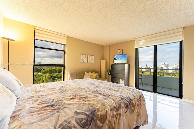 bedroom featuring access to outside, multiple windows, a textured ceiling, and french doors