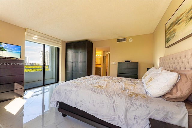 bedroom with marble finish floor, access to outside, visible vents, and a textured ceiling