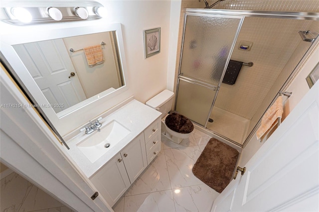 bathroom featuring a shower stall, toilet, vanity, and marble finish floor