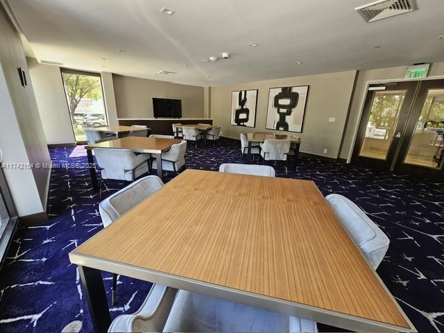 carpeted dining space featuring visible vents