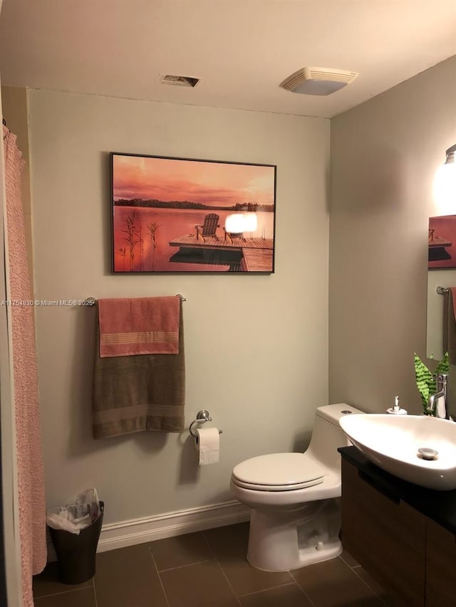 bathroom featuring tile patterned flooring, baseboards, vanity, and toilet