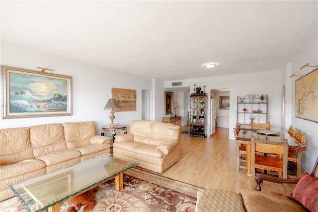 living area with visible vents and light wood-style floors