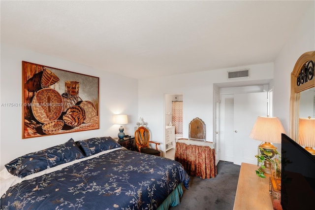 carpeted bedroom with visible vents and ensuite bath