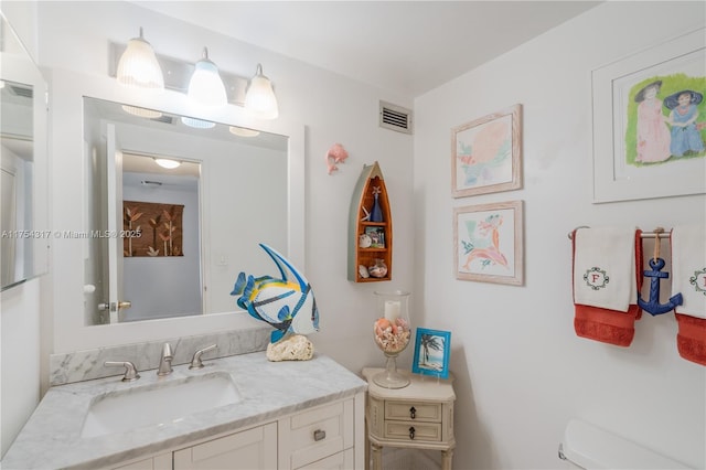 bathroom featuring visible vents, vanity, and toilet