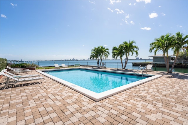 pool with a patio and a water view