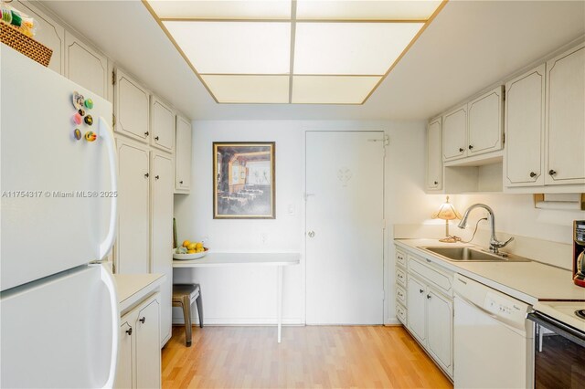 1700 NE 105th St Unit 216, Miami Shores, FL 33138 - kitchen with white appliances, a sink, light countertops, and light wood-type flooring