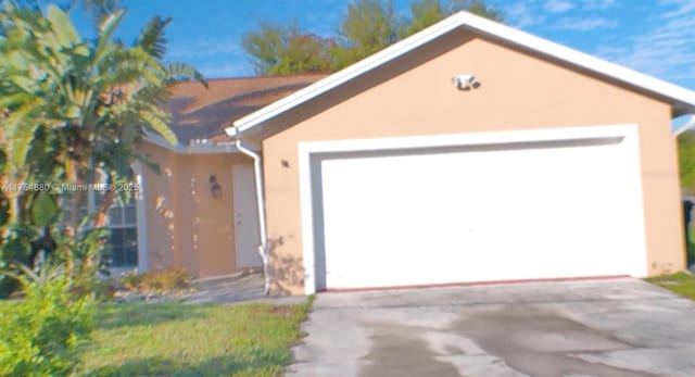 view of front of property with an attached garage, concrete driveway, and stucco siding