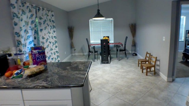 dining space featuring light tile patterned floors and baseboards