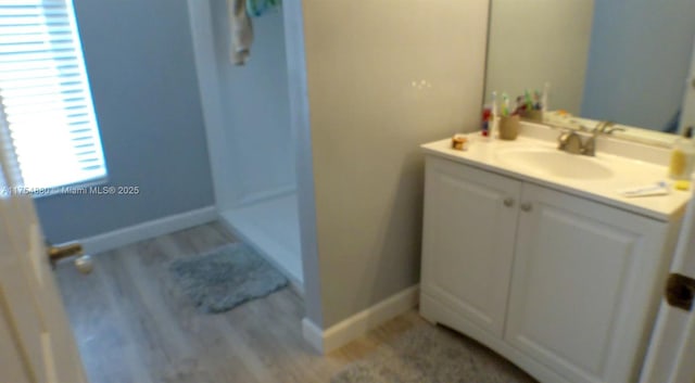 full bathroom with vanity, baseboards, and wood finished floors