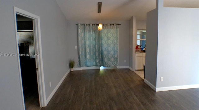 unfurnished dining area with baseboards and wood finished floors