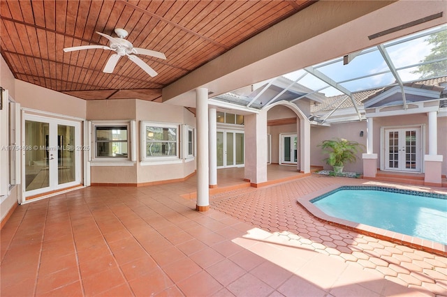 pool featuring glass enclosure, ceiling fan, a patio, and french doors