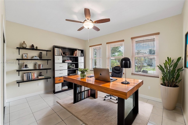 office space with light tile patterned floors, ceiling fan, and baseboards