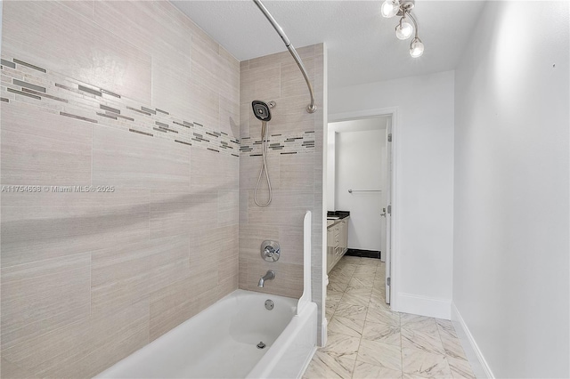 full bath with marble finish floor, tub / shower combination, vanity, and baseboards