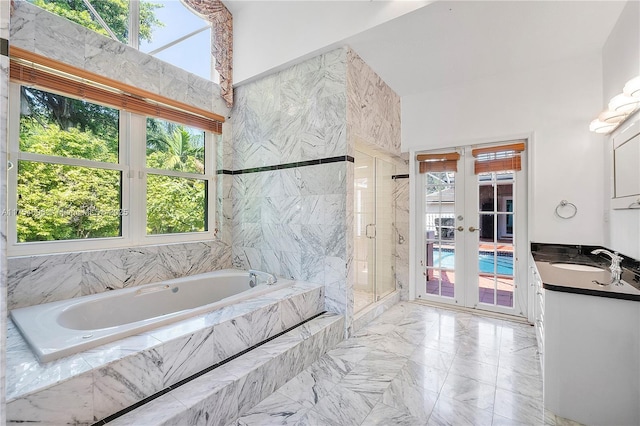 full bathroom featuring a garden tub, vanity, marble finish floor, french doors, and a shower stall