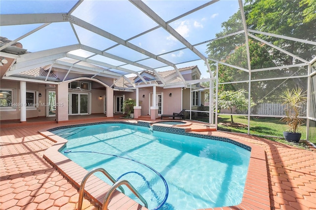 outdoor pool with a lanai, a patio area, and an in ground hot tub