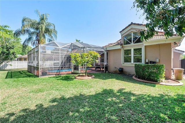 view of yard featuring glass enclosure, fence, and an outdoor pool