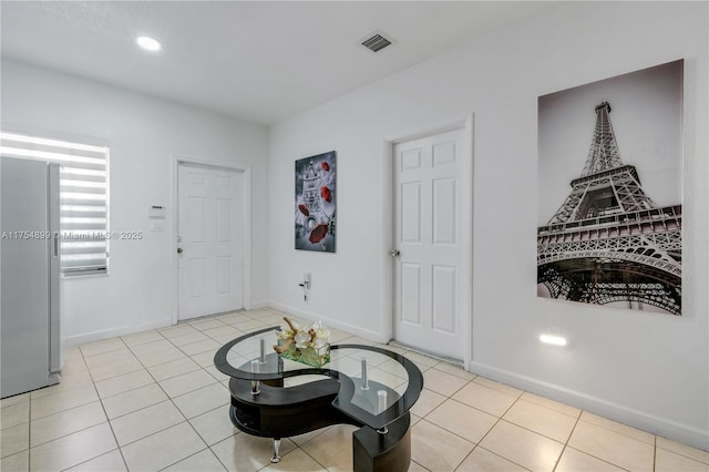 tiled foyer entrance featuring baseboards and visible vents