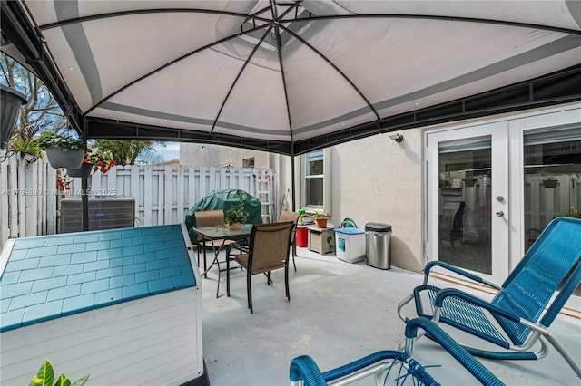 view of patio featuring a gazebo, fence, central AC, and outdoor dining space