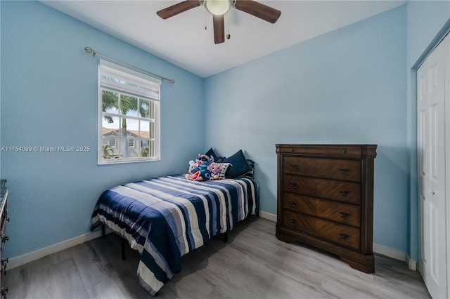 bedroom featuring ceiling fan, baseboards, and wood finished floors