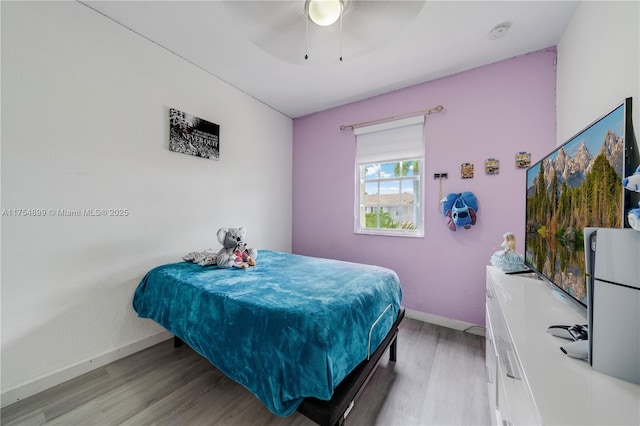 bedroom with light wood-style flooring, baseboards, and ceiling fan