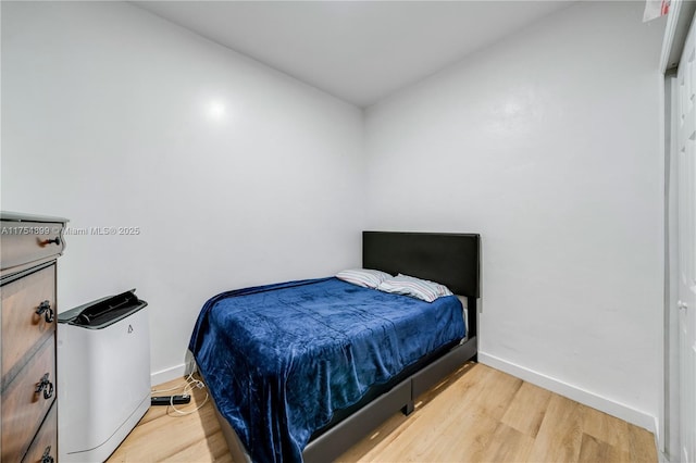 bedroom featuring baseboards and wood finished floors