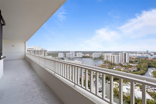 balcony with a water view and a view of city